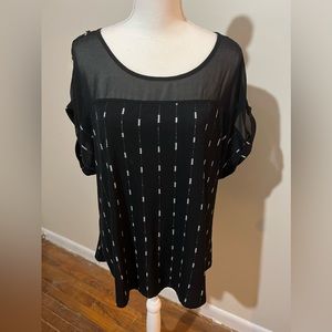 Plus-size black top with white arrows and sheer neck